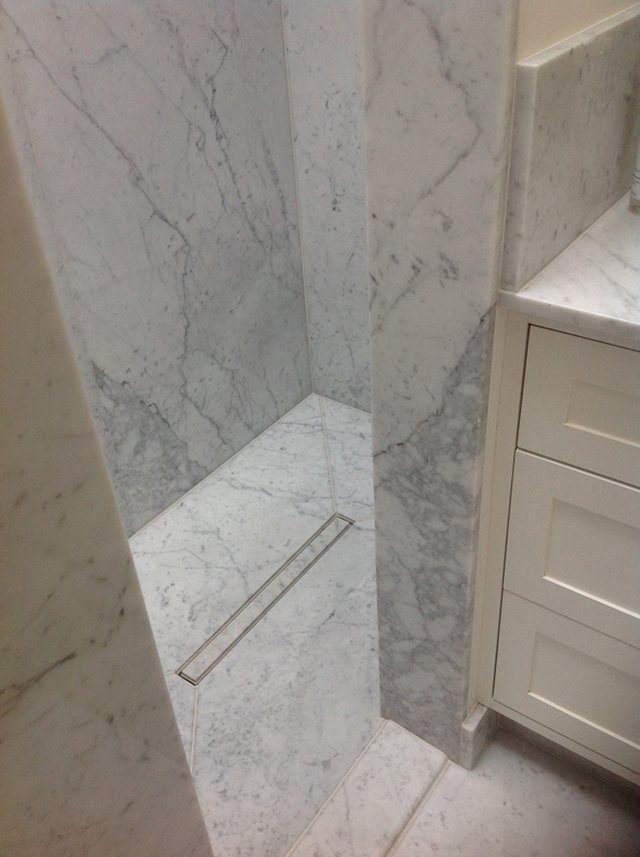 Marble walk-in shower and marble flooring